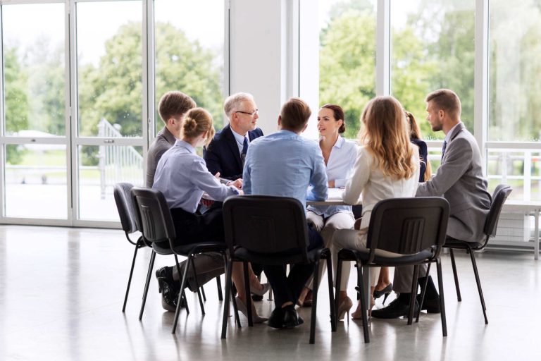 Group of professionals discussing eligibility criteria for EU funding during a strategic meeting in a bright, modern office.