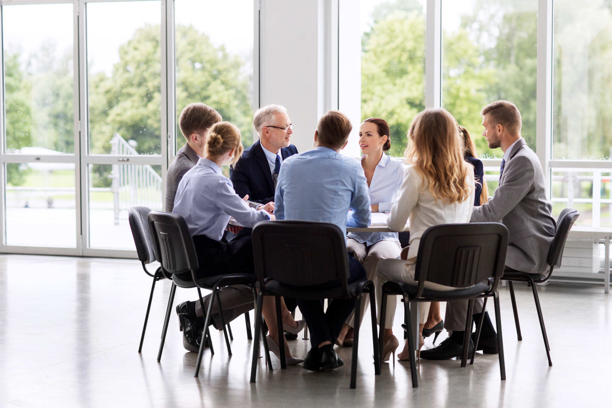 Group of professionals discussing eligibility criteria for EU funding during a strategic meeting in a bright, modern office.